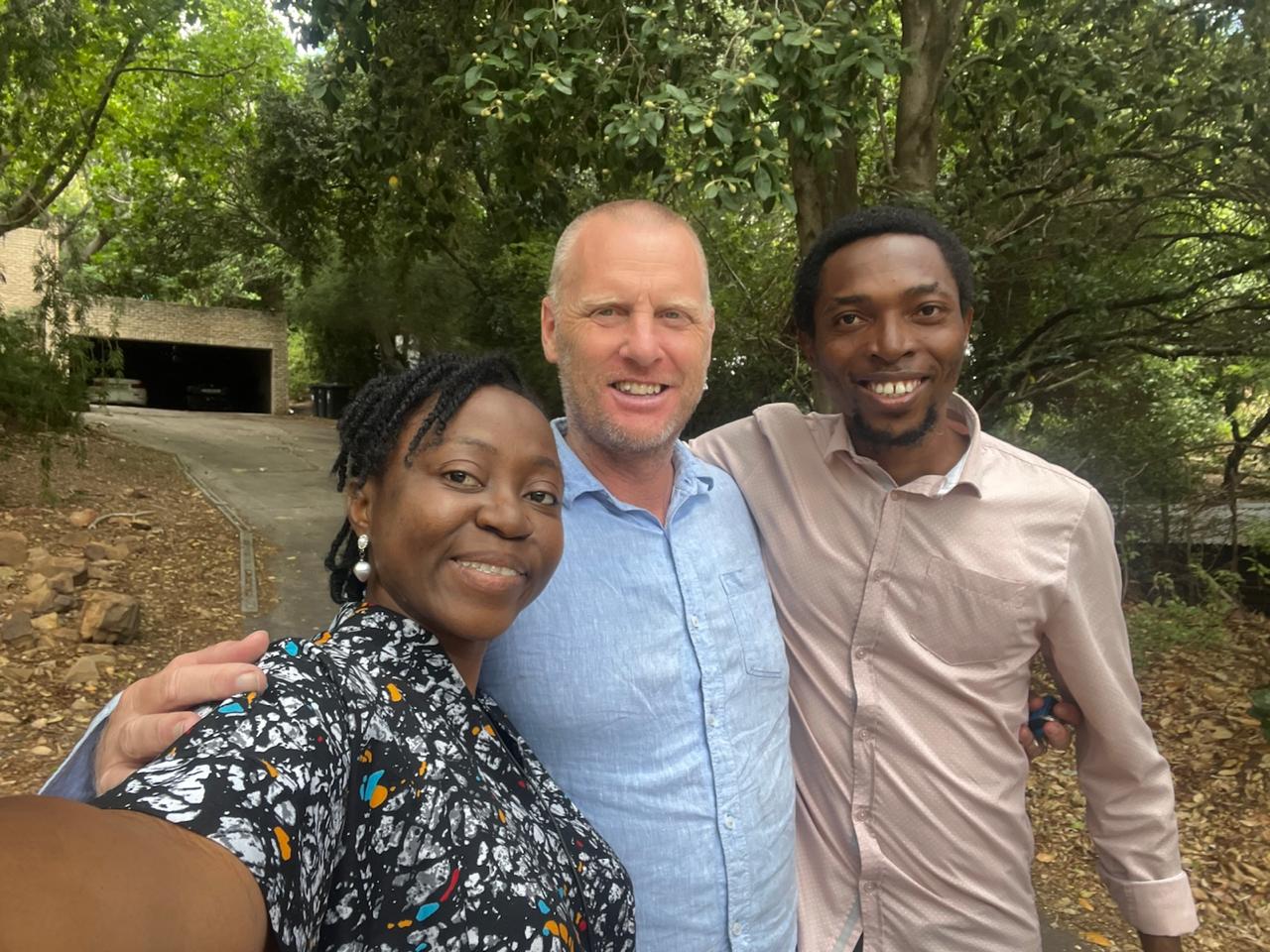 Grace Damilola taking a selfie with two smiling brothers under the trees