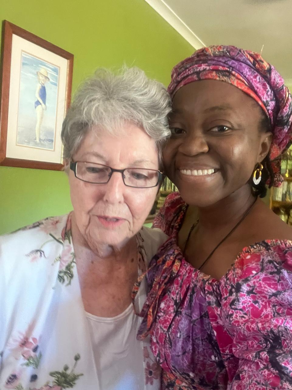 Grace Damilola taking a close selfie with a sister wearing a green scarf