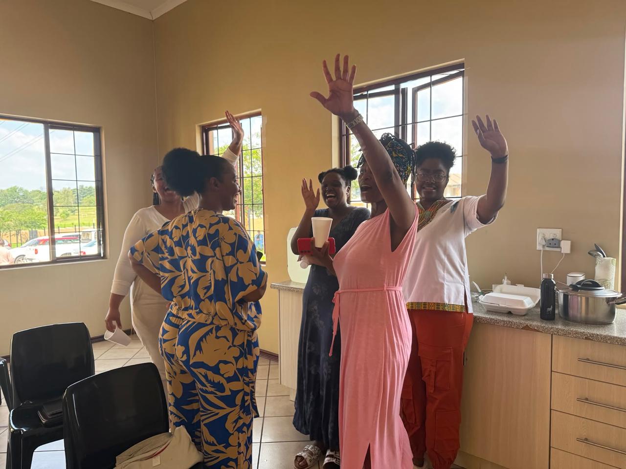 Sisters praising and waving their hands joyfully in the kitchen